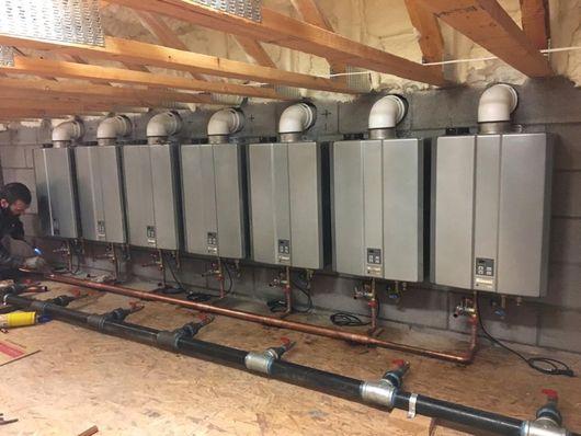 row of commercial tankless water heaters being installed