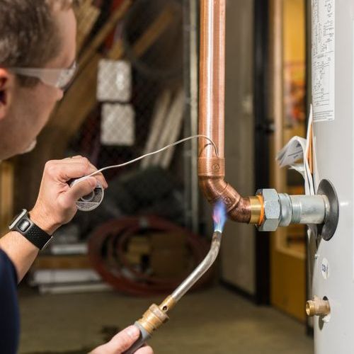Picture of a plumber repairing copper pipe on water heater