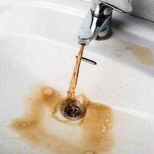 Picture of rusty brown water coming out of the sink faucet