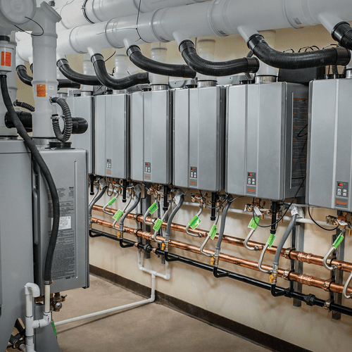 Picture of a row of tankless water heaters installed for commercial use